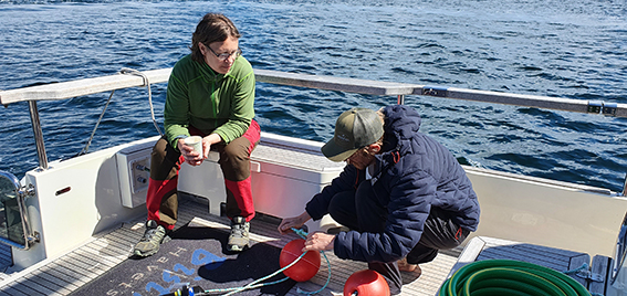 Bild på forskare som sitter i en båt och förbereder utplacering av utrustning i havet